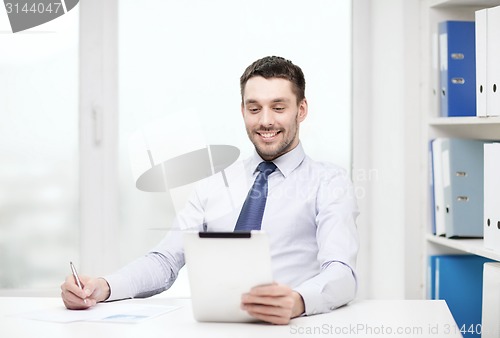 Image of smiling businessman with tablet pc and documents