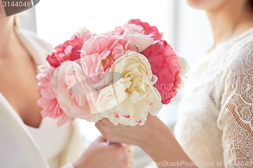 Image of close up of happy lesbian couple with flowers