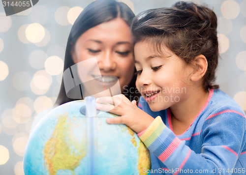 Image of happy mother and daughter with globe