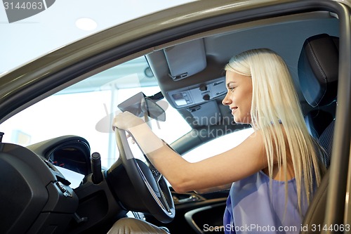 Image of happy woman inside car in auto show or salon