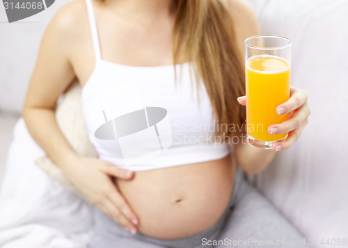 Image of close up of happy pregnant woman with orange juice
