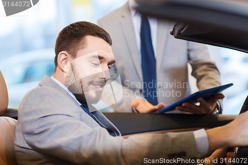 Image of happy man with car dealer in auto show or salon