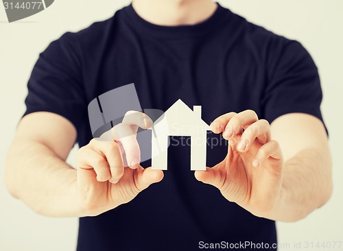 Image of man hands holding paper house