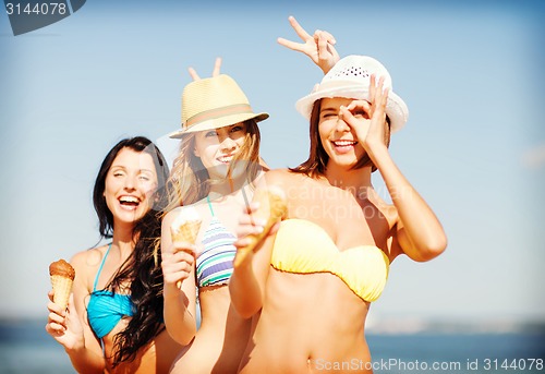 Image of girls in bikini with ice cream on the beach