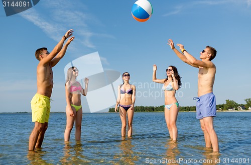 Image of smiling friends in sunglasses on summer beach