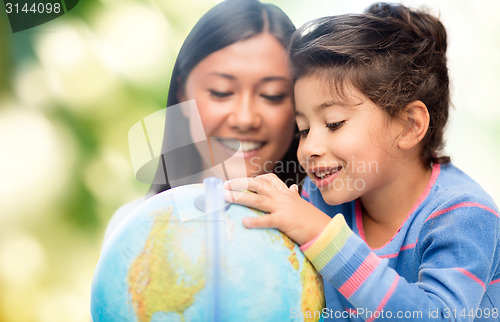 Image of happy mother and daughter with globe