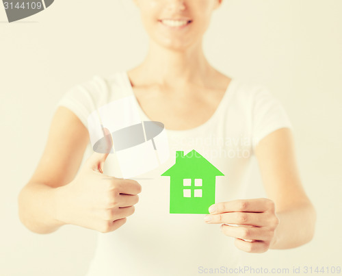 Image of woman hands holding green house