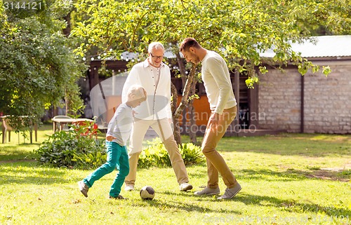 Image of happy family playing football outdoors