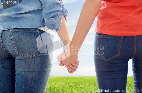 Image of close up of lesbian couple holding hands