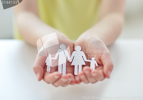 Image of close up of child hands with paper family cutout
