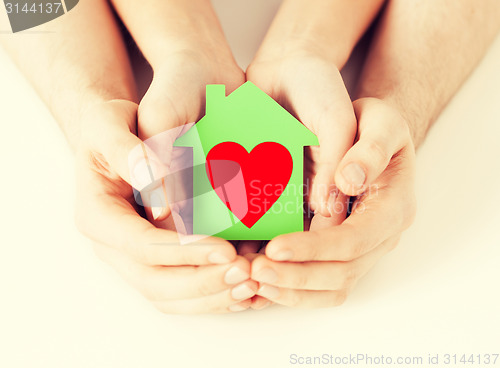 Image of couple hands holding green paper house