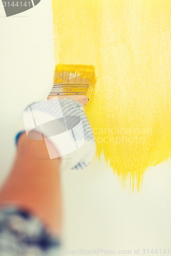 Image of close up of male in gloves holding paintbrush