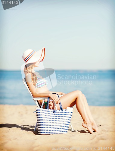 Image of girl sunbathing on the beach chair