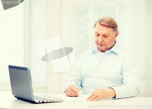 Image of old man filling a form at home