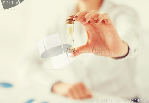 Image of woman hand with sandglass