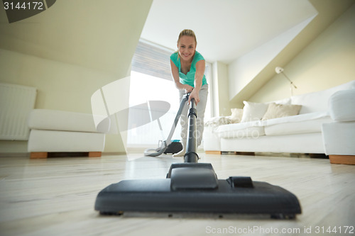 Image of happy woman with vacuum cleaner at home