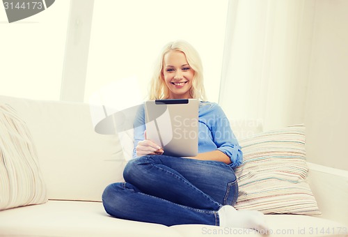 Image of smiling woman with tablet pc computer at home