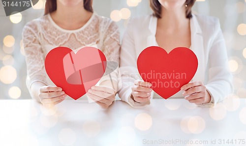 Image of close up of happy lesbian couple with red hearts