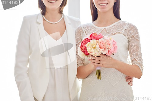 Image of close up of happy lesbian couple with flowers