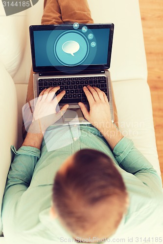 Image of close up of man working with laptop at home