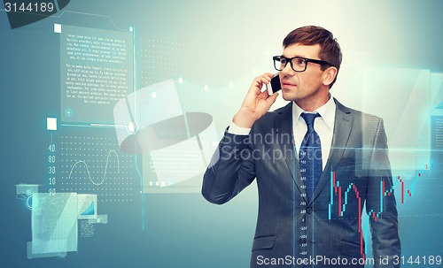 Image of buisnessman with cell phone and forex chart