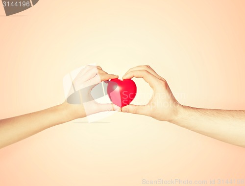 Image of woman and man hands with heart