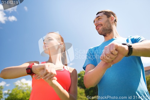 Image of smiling people with heart rate watches outdoors