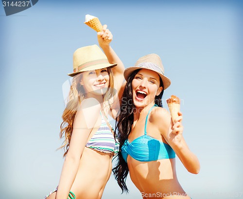 Image of girls in bikini with ice cream on the beach