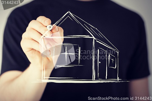 Image of man drawing a house on virtual screen