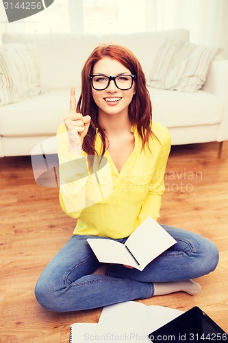 Image of smiling teenage girl with tablet pc at home