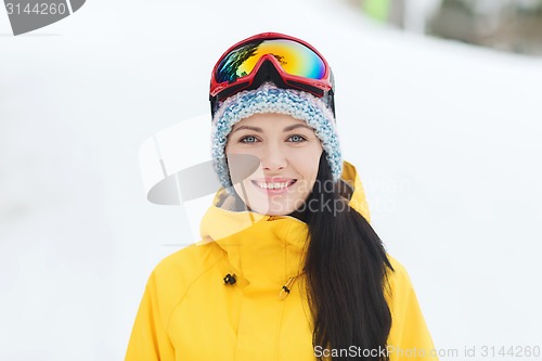 Image of happy young woman in ski goggles outdoors