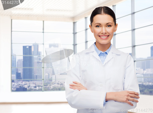 Image of smiling young female doctor in white coat