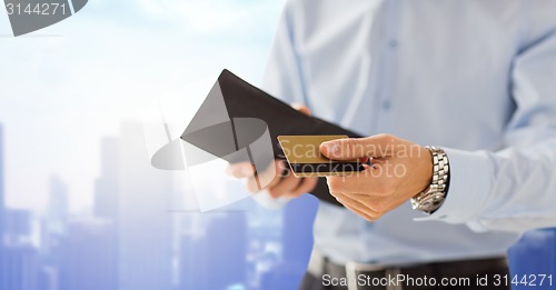 Image of close up of man holding wallet and credit card