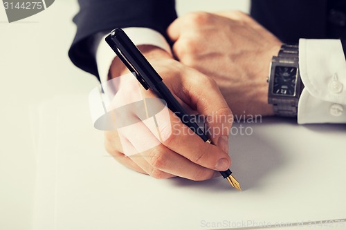 Image of businessman writing something on the paper