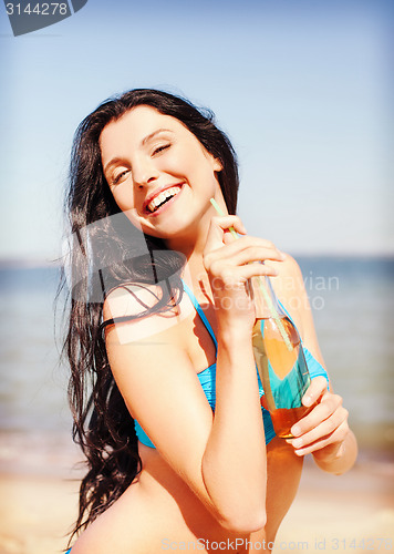 Image of girl with bottle of drink on the beach