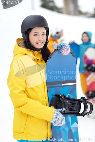 Image of happy friends in helmets with snowboards