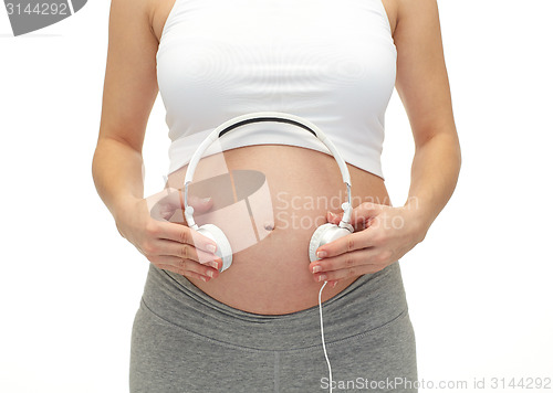 Image of close up of pregnant woman and headphones on tummy