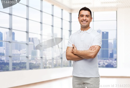 Image of smiling man in white t-shirt over office or home