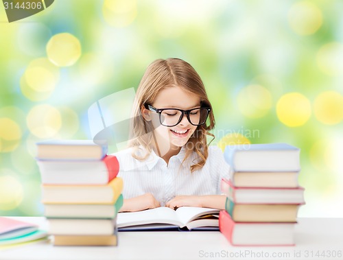 Image of happy student girl reading book at school