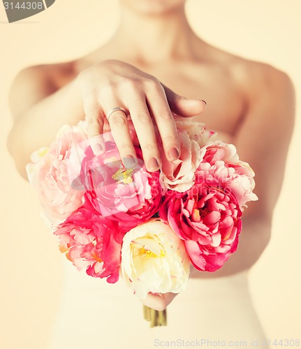 Image of bride with bouquet of flowers and wedding ring