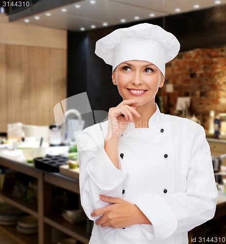 Image of smiling female chef dreaming