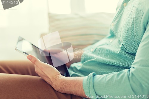 Image of close up of man with tablet pc computer at home