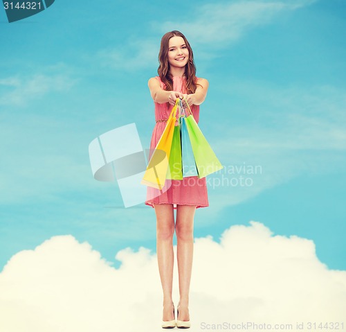 Image of smiling woman in dress with many shopping bags