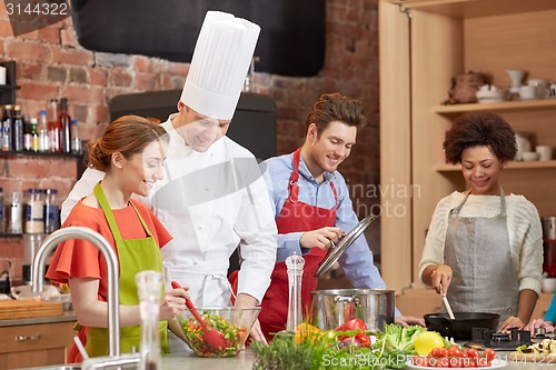 Image of happy friends and chef cook cooking in kitchen