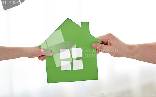 Image of close up of child and father hands with house