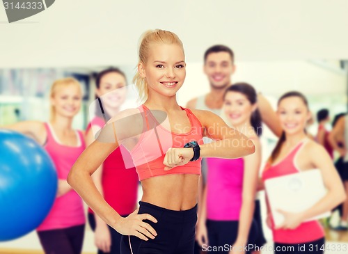 Image of smiling woman with heart rate monitor on hand