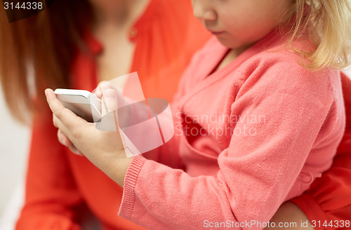 Image of close up of woman and little girl with smartphone