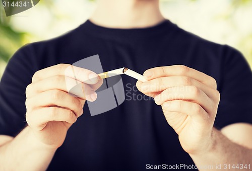 Image of man breaking the cigarette with hands