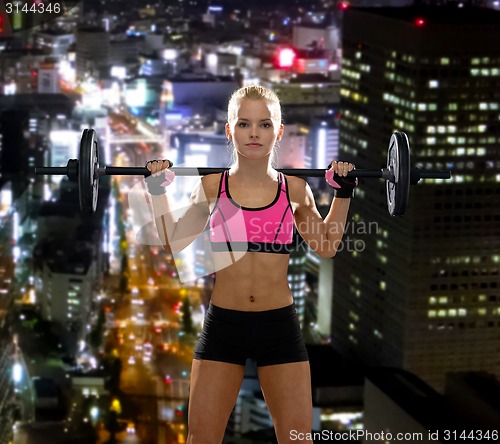 Image of sporty woman exercising with barbell