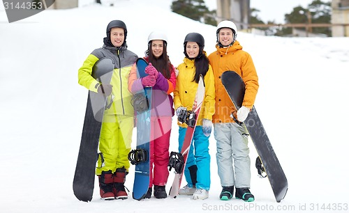 Image of happy friends in helmets with snowboards